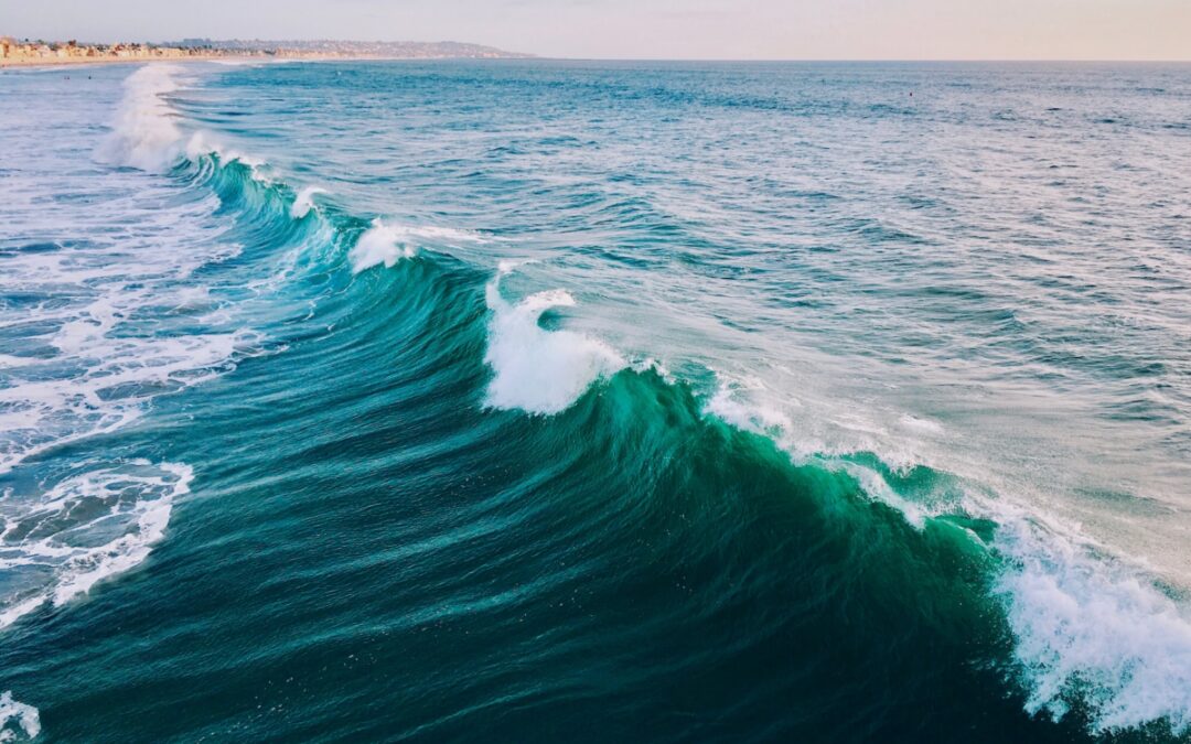 A close up of bluish teal waves with white caps