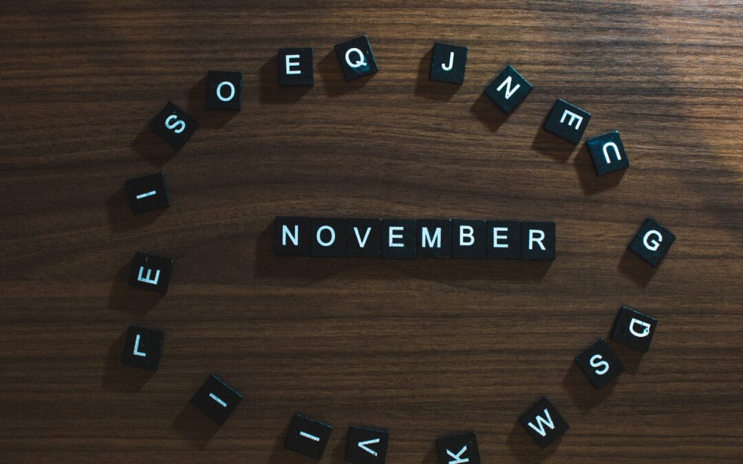 Small block letters spelling out "November" on a wood surface